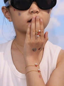 Detalle de un conjunto de joyas infantiles con perlas y estrellas doradas en modelo