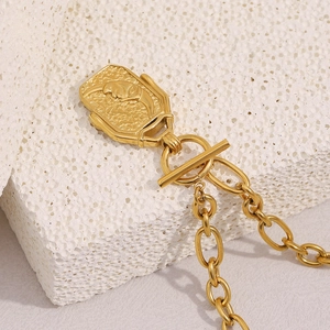 Macro detail of 18K gold-plated moon square pendant with T-bar clasp on stone
