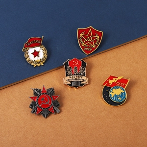 Five assorted Soviet CCCP themed metal enamel star badges on a blue and brown background