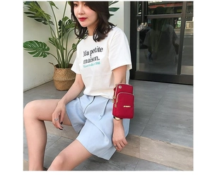 Outdoor sports red nylon phone bag worn as arm bag shown by model in casual setting