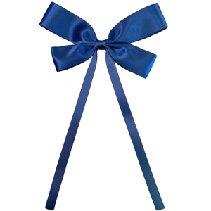 Close-up of a blue satin bow hair clip with long ribbons and a glossy finish