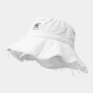 Dettaglio del cappello pescatore in tela bianca con bordi sfrangiati e toppa con logo Brooklyn