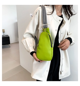Dettaglio borsa a tracolla verde brillante in pelle martellata con tracolla intrecciata