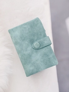 Short mint green bifold wallet in frosted leather on white plush background