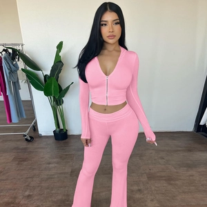 Detail of pink two-piece knit set featuring zip-up hoodie and high-waisted flare pants