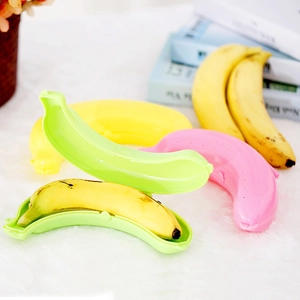 Three colorful plastic banana protectors in pink, yellow, and green for fruit storage