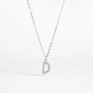 Macro shot of silver letter D pendant necklace featuring sparkling cubic zirconia stones