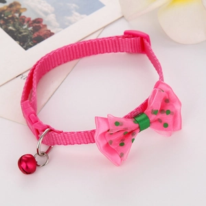 Detailed view of pink polka dot pet collar with red bell and secure buckle