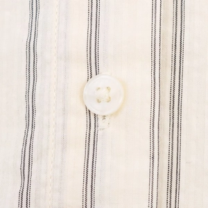 Detailed macro view of retro striped shirt fabric with a classic four-hole button detail