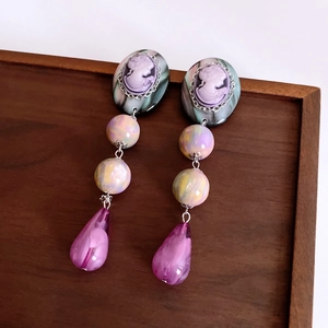 Detail of vintage cameo drop earrings with purple beads and resin teardrop pendants