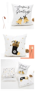 Detailed view of Christmas pillow covers with gold bells and Season's Greetings prints