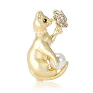 Exquisite golden cat brooch with large pearl and rhinestone butterfly on white background