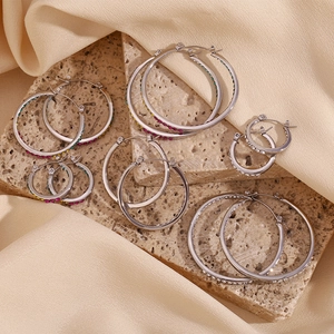 Hoop earrings in various sizes with colorful rhinestones on a textured stone plate