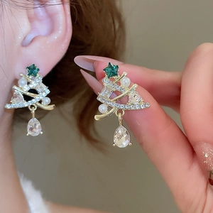 Detailed view of Christmas tree earrings with pearls and crystals on a model's ear