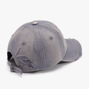 Vintage washed baseball cap in grey blue with distressed ripped brim and metal buckle