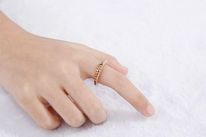 Macro detail of rose gold titanium croissant ring with unique spiral texture on finger