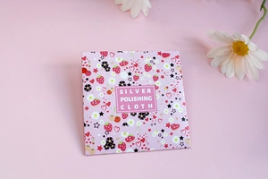 Macro detail of strawberry-themed pink packaging for silver polishing cloth jewelry care