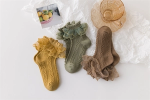 Flat lay of cotton lace trim socks for girls in yellow, green, and brown colors