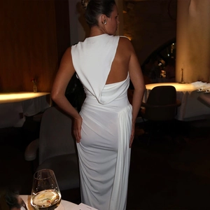 Detail of elegant white backless sleeveless dress showing the draped fabric and slit
