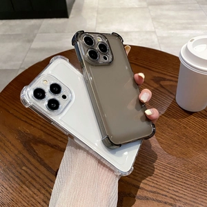 Transparent and smoke grey shockproof iPhone cases with reinforced corners on a wooden desk