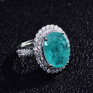 Close-up of a pear-shaped Paraiba tourmaline ring with double halo pavé diamonds