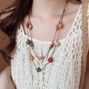 Dettaglio di collana bohémien a doppio strato con perline in ceramica colorate su pizzo