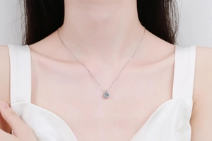 Detailed close-up of a minimalist 1ct moissanite pendant on a 925 silver chain worn by model