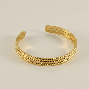 Detailed view of the 18K gold plated triple-strand braided texture on the open cuff bracelet
