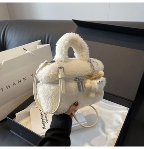 Detail of white plush handbag in gift box with cute charm and adjustable strap