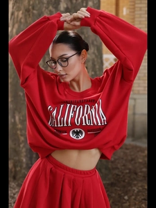 Dettaglio del set felpa rossa con stampa California e gonna a pieghe