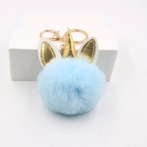 Détail du porte-clés licorne en peluche bleu ciel avec corne dorée et fermoir métal