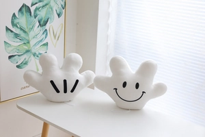 Detail of plush cartoon palm gloves with soft fabric and embroidered smiling face
