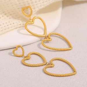 Detail of 18K gold-plated stainless steel triple heart earrings with snake skin texture
