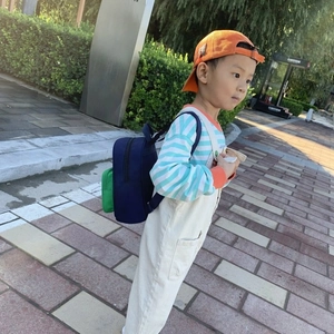 Navy and green color block kids backpack for school boys on a boy model