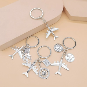 Close-up of airplane and world map charms with engraved 'no matter where' on silver keychains