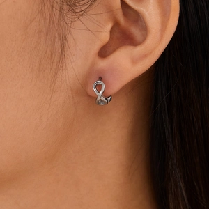 Minimalist silver stainless steel infinity stud earrings worn on the earlobe for a sleek look