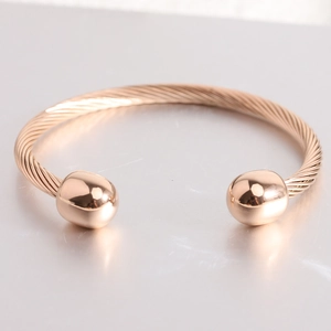 Detail of rose gold cable twist cuff bracelet with polished spherical ends