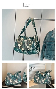 Detail of green nylon tote bag featuring white skull and dark rose floral patterns