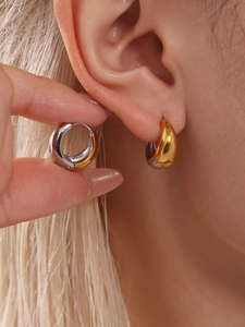 Gros plan de boucles d'oreilles créoles bicolores or et argent avec finition polie miroir