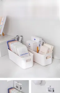 White plastic storage box with handles organizing stationery and phone cases on a desk