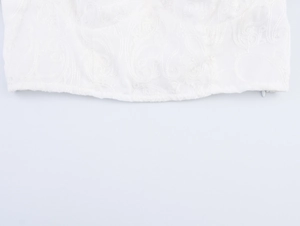 Gros plan sur la broderie florale blanche et la fermeture éclair invisible du haut