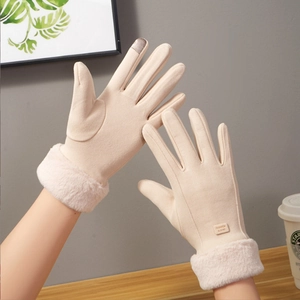 Detail of winter warm gloves in beige suede with faux fur cuffs and touchscreen fingers