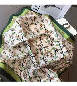 Detail of silk scarf with green floral butterfly print and matching luxury handbag