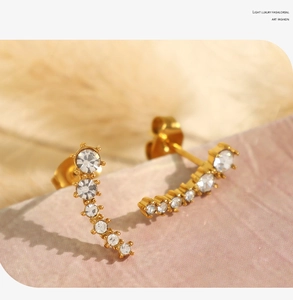 Macro detail of gold-plated crescent ear climbers with sparkling gradient zircons