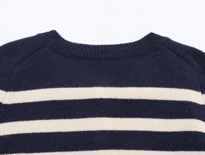 Detail of navy blue and off-white striped knit sweater with ribbed round neckline