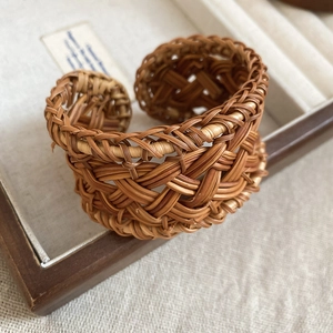 Detailed close-up of handmade woven rattan bangle texture and bohemian craft details