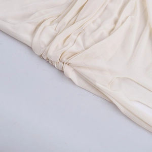 Detailed macro shot of white ruched mesh fabric texture and fine stitching on the dress