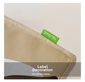 Detail of the high-quality canvas stitching and green woven TBJ BAG label on the side