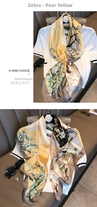 Detail of elegant zebra print silk scarf in pear yellow and brown on white knitwear