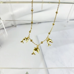 Detailed close-up of gold plated stainless steel necklace with three dolphin pendants